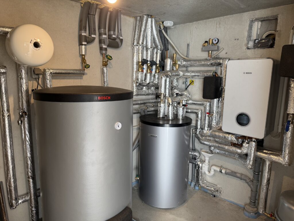 Heizungsraum mit Wärmepumpen-Technik und Pufferspeichern von Bosch