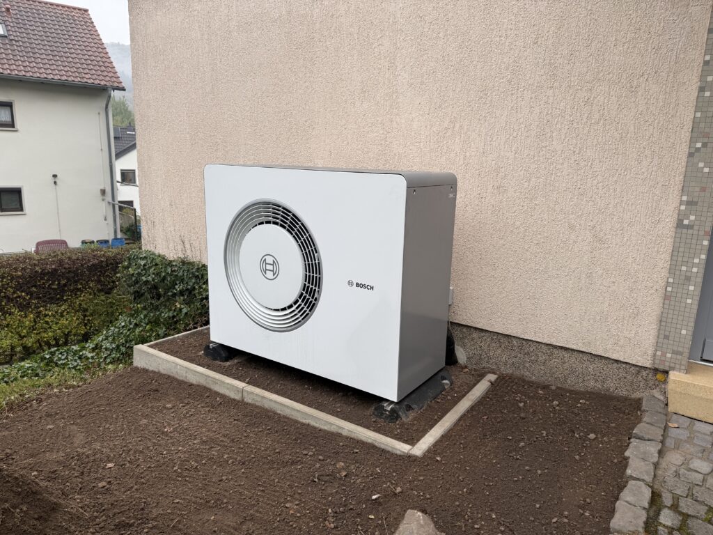 Bosch Wärmepumpen-Außengerät an einer Hauswand im Altbau